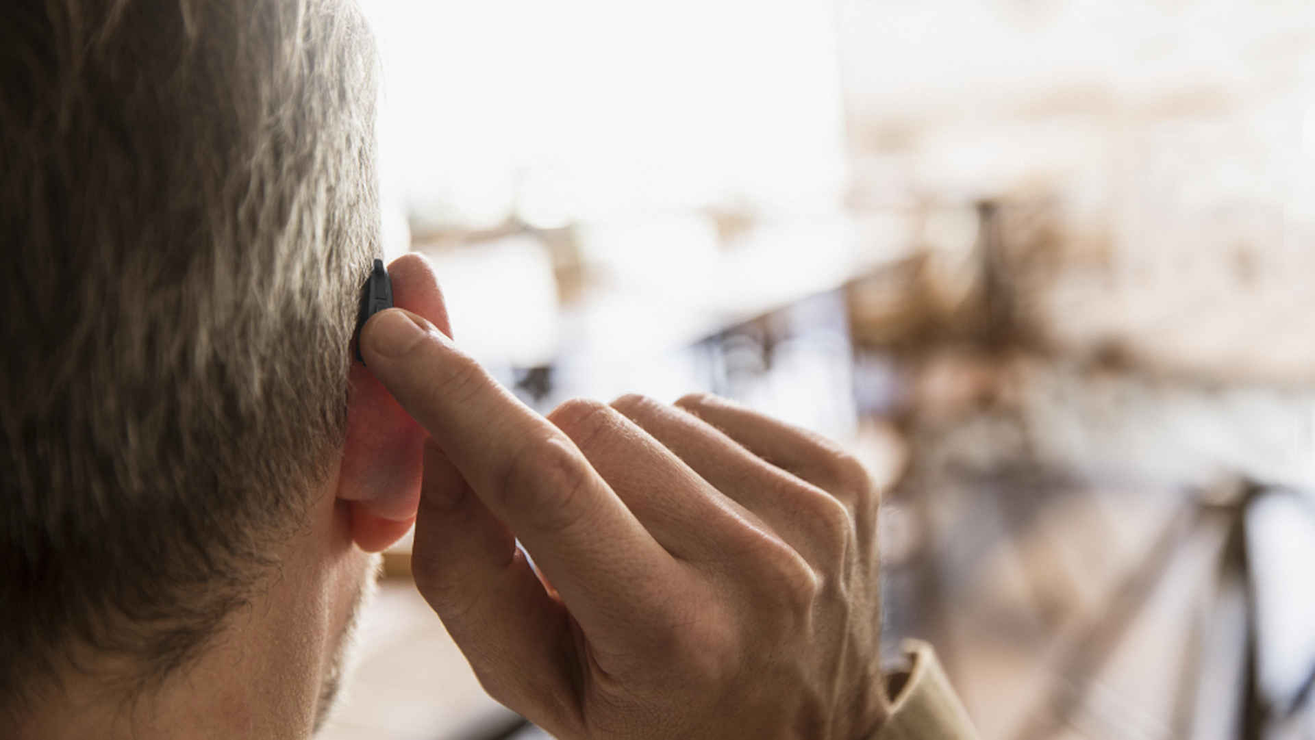 Man with hearing aids - view from behind